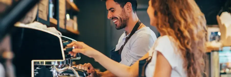 Viser to ansatte der er ved at lave kaffe på en cafe